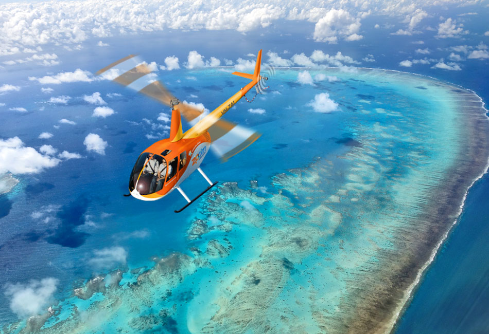 An orange helicopter flies over a vibrant blue ocean with coral reefs and scattered clouds below.
