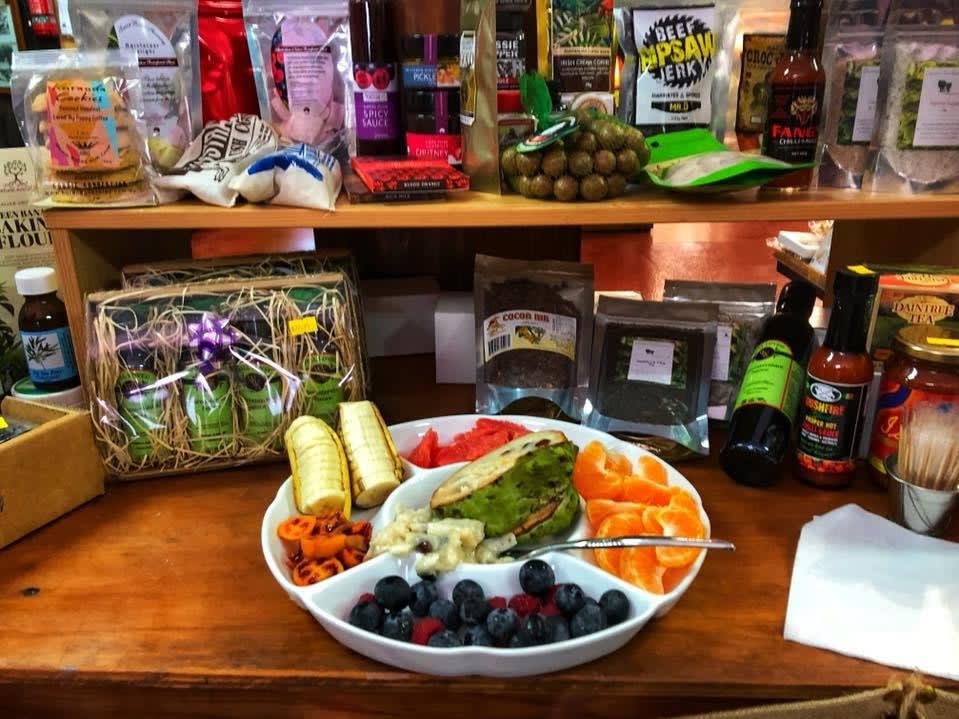 A plate of assorted fruits and vegetables sits on a counter, surrounded by various packaged food items and condiments on shelves in the background.